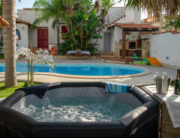 Piscina con angolo barbecue e vasca idromassaggio